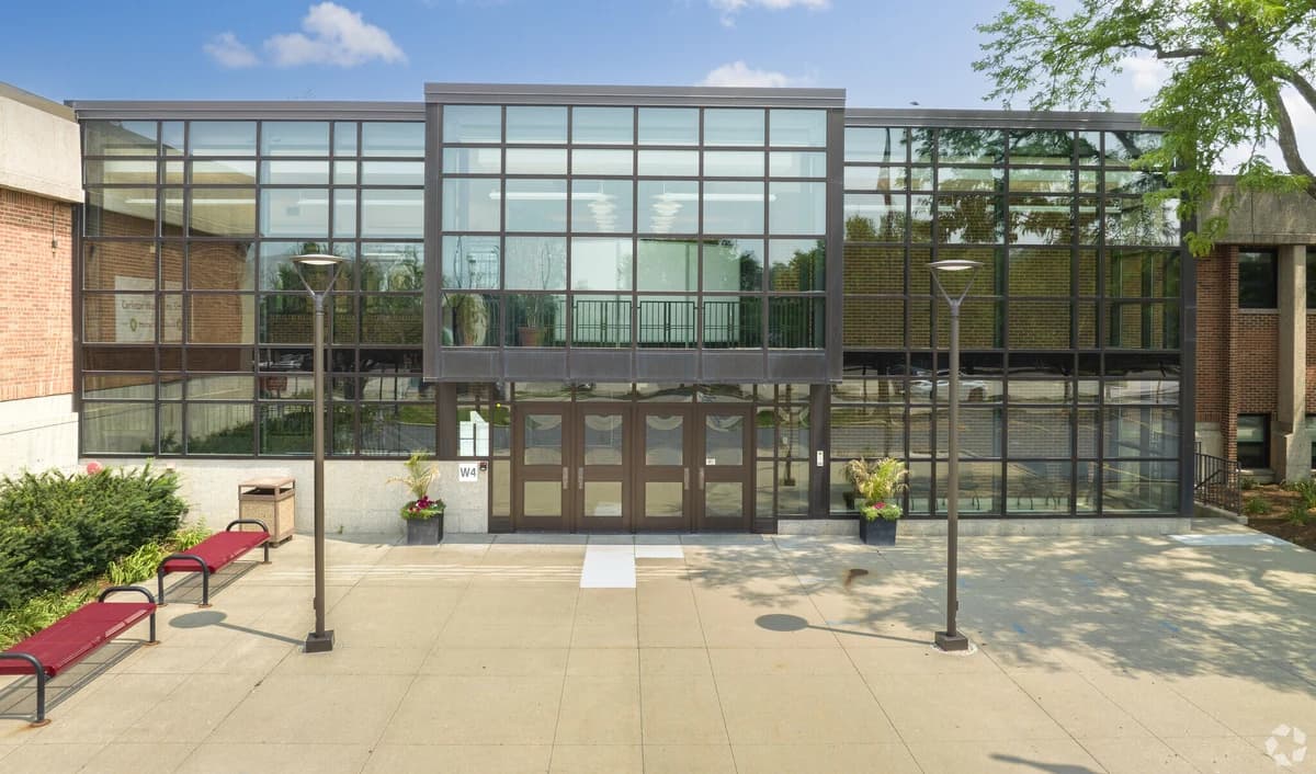 School entrance with a two-story glass facade and a landscaped entry plaza